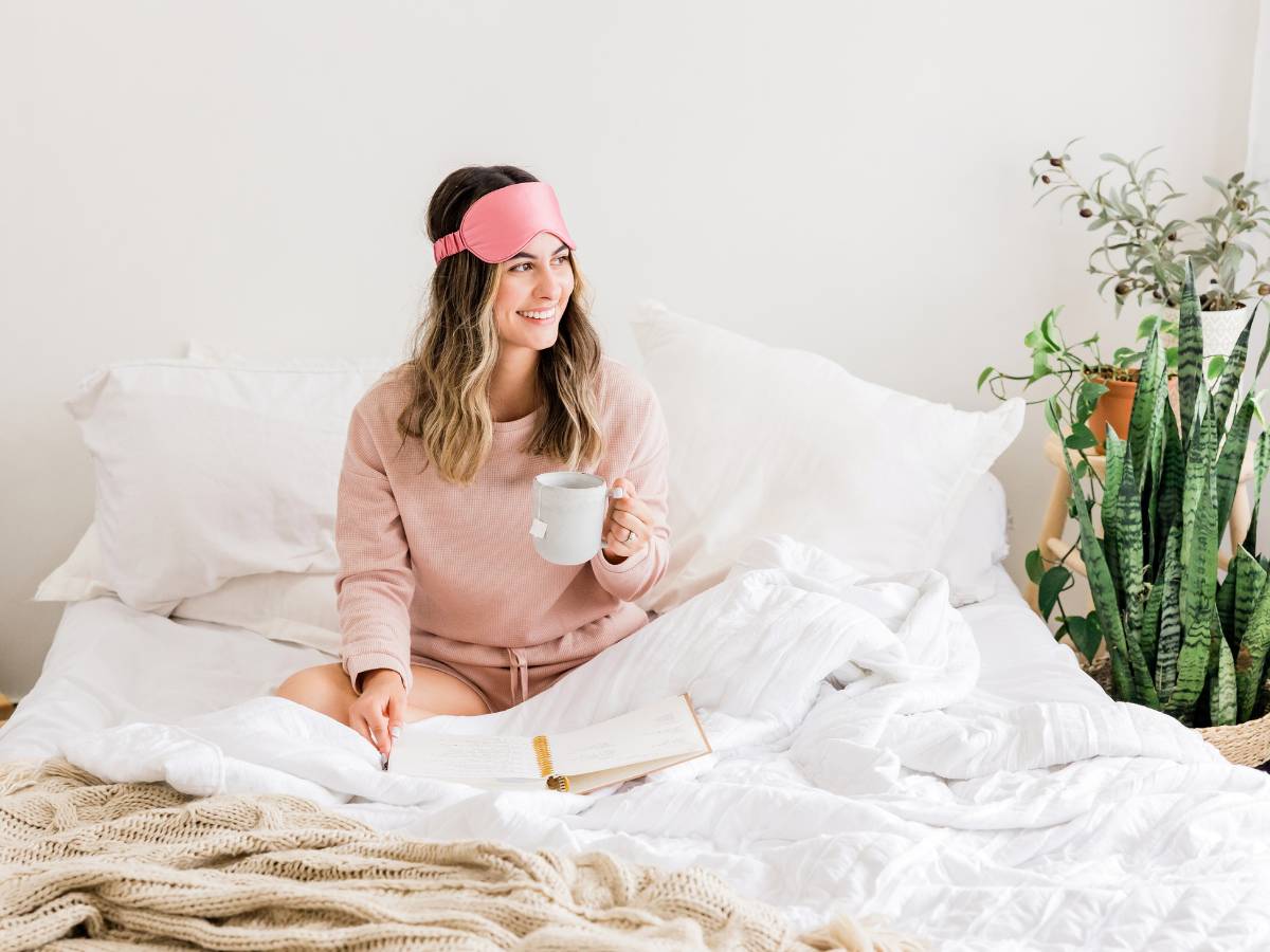 Kobieta w łóżku z herbatą. Obrazek w artykule Jakie herbaty na dobry sen? Odkryj ziołowe sposoby na zasypianie